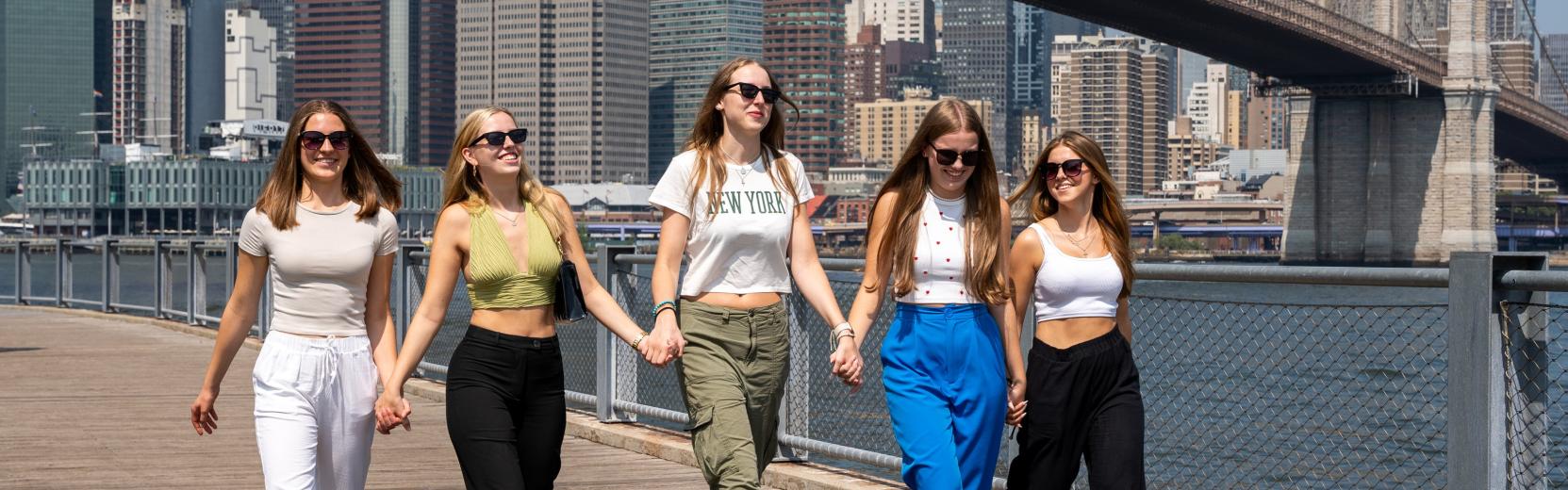 five female au pairs walking side by side in manhattan