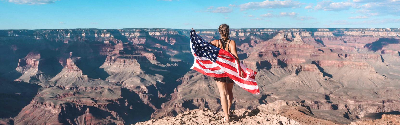 5 Reasons to Become an Au pair au pair holding an american flag in the Grand Canyon
