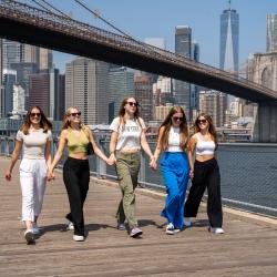 five female au pairs walking side by side in manhattan